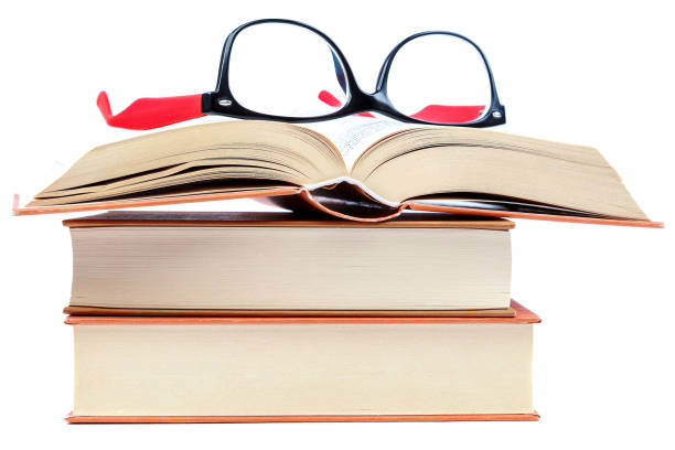 istock Open book and glasses on a stack of books 982896128