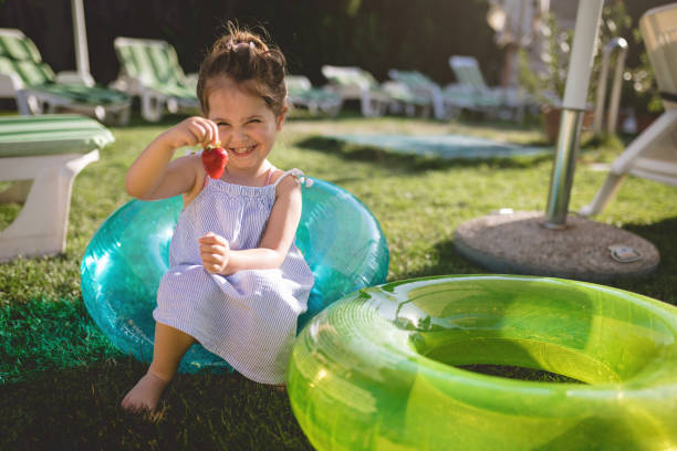 istock Smiling girl holding a ripe strawberry 982921454