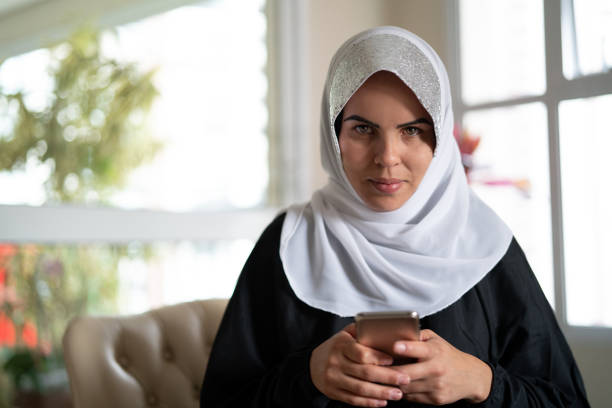 istock Muslim woman using mobile at home 982969478