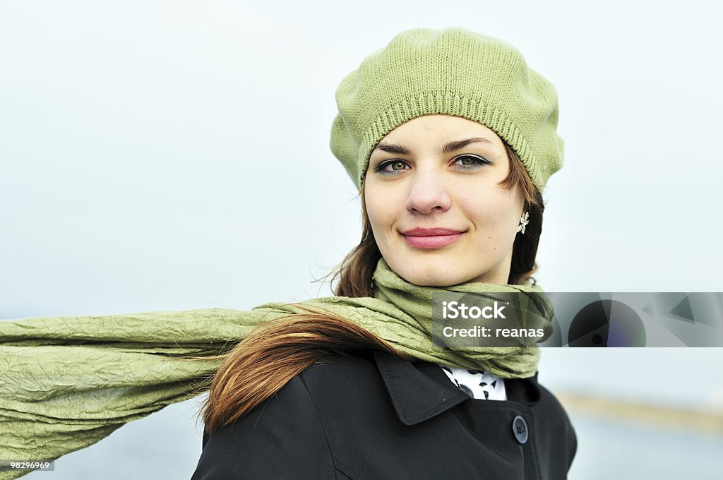 Woman in green hat and green scarf on a windy day  	attractive teenage girl wearing beret standing outdoors in windy day Adolescence Stock Photo