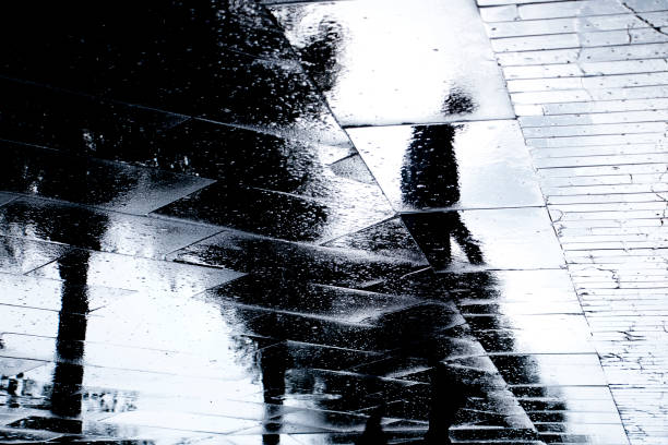 Blurry reflection  silhouettes of  a man walking on a rainy day