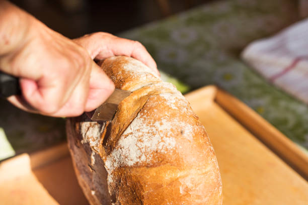 istock The woman cuts a loaf of bread for two half 982982330