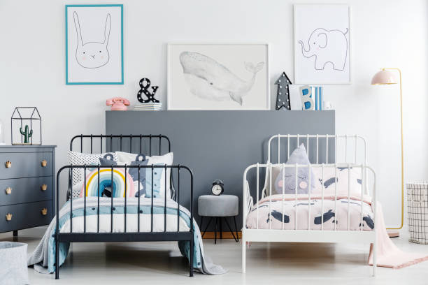 istock Grey stool between black and white bed in children bedroom interior with posters. Real photo 982989112