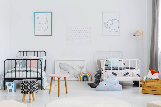 istock Patterned stool in spacious children bedroom interior with posters above white and black bed. Real photo 982989132