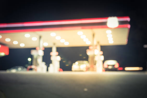 istock Vintage blurred gas station with car refueling at night 983024864