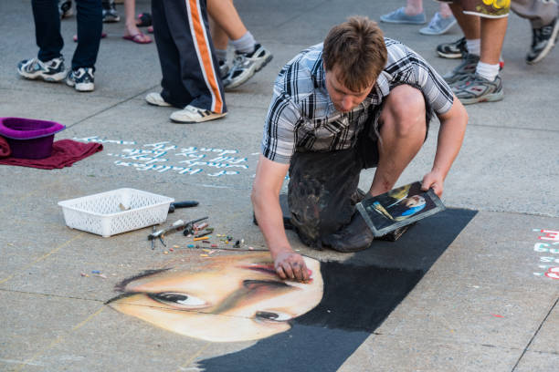 Halifax, Canada - July 29, 2015 -An artist creates a detailed chalk drawing on the Halifax waterfront during the International Buskers Festival.
