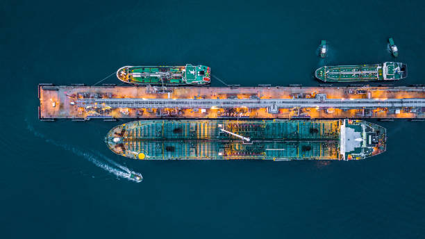 aerial top view of oil tanker ship at the port, aerial view oil terminal is industrial facility for storage of oil and petrochemical products ready for transport to further storage facilities. - oil tanker tanker oil sea imagens e fotografias de stock