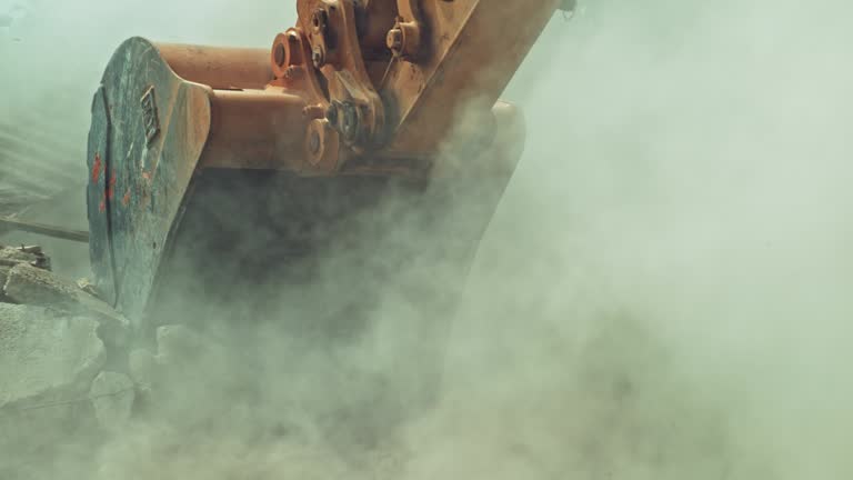 SLO MO Cloud of dust lifted into the air as the excavator demolishes an old building