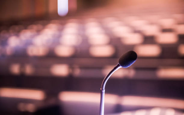 istock Microphone over the blurred business forum Meeting or Conference Training Learning Coaching Room Concept, Blurred background 983098750