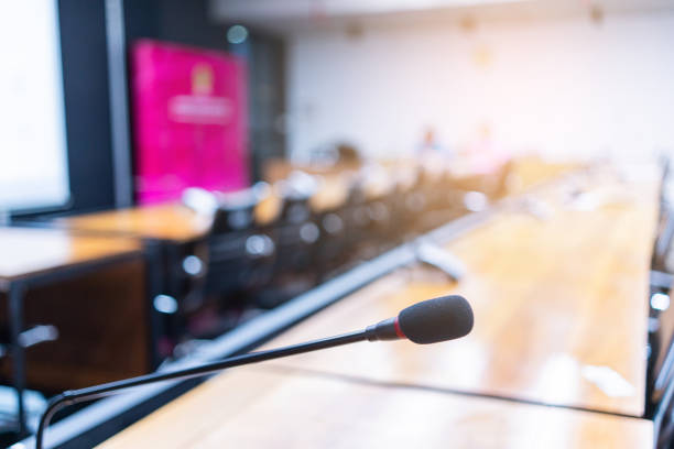 istock Microphone over the blurred business forum Meeting or Conference Training Learning Coaching Room Concept, Blurred background 983098876