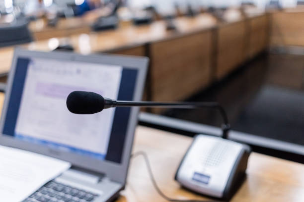 istock Microphone over the blurred business forum Meeting or Conference Training Learning Coaching Room Concept, Blurred background 983099008