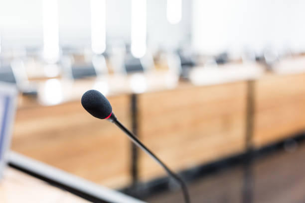 istock Microphone over the blurred business forum Meeting or Conference Training Learning Coaching Room Concept, Blurred background 983099036