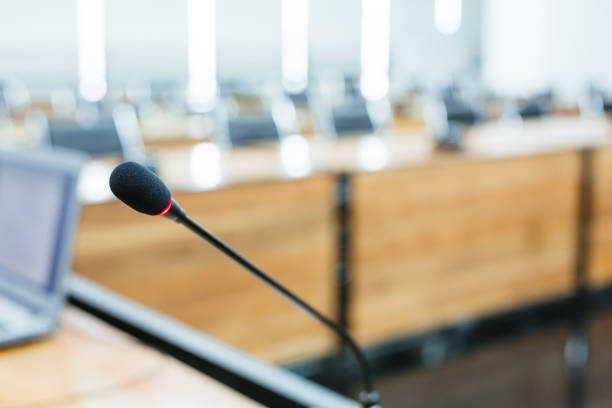 istock Microphone over the blurred business forum Meeting or Conference Training Learning Coaching Room Concept, Blurred background 983099038