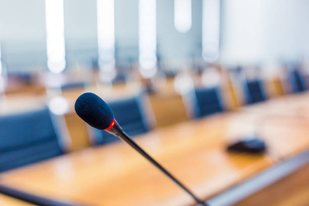 istock Microphone over the blurred business forum Meeting or Conference Training Learning Coaching Room Concept, Blurred background 983099060