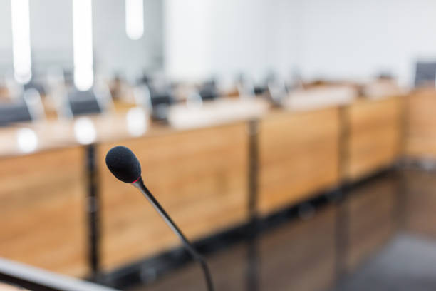 istock Microphone over the blurred business forum Meeting or Conference Training Learning Coaching Room Concept, Blurred background 983099066