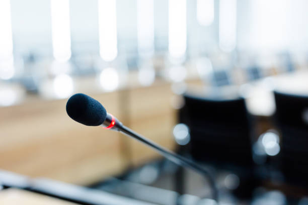 istock Microphone over the blurred business forum Meeting or Conference Training Learning Coaching Room Concept, Blurred background 983099084
