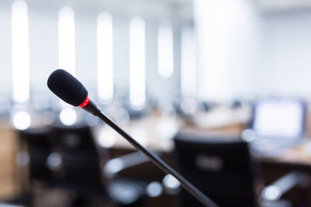 istock Microphone over the blurred business forum Meeting or Conference Training Learning Coaching Room Concept, Blurred background 983099108