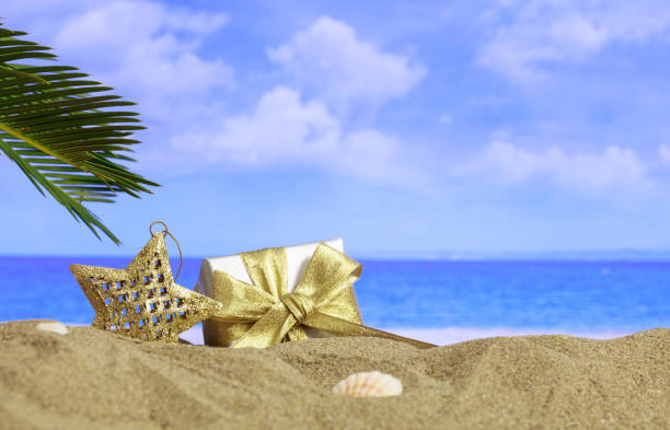 istock Christmas star and gift on beach 983099116