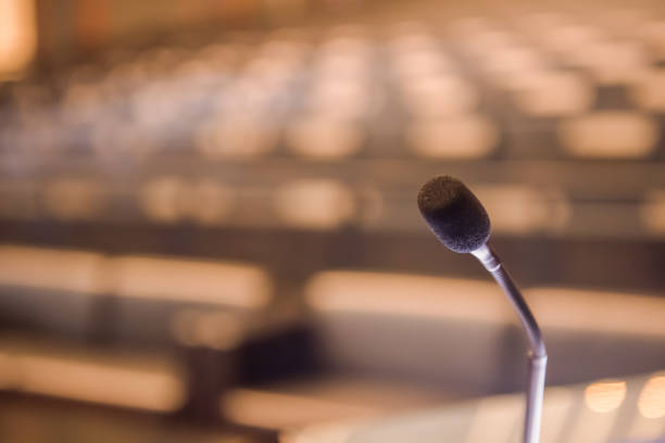 istock Microphone over the blurred business forum Meeting or Conference Training Learning Coaching Room Concept, Blurred background 983101866
