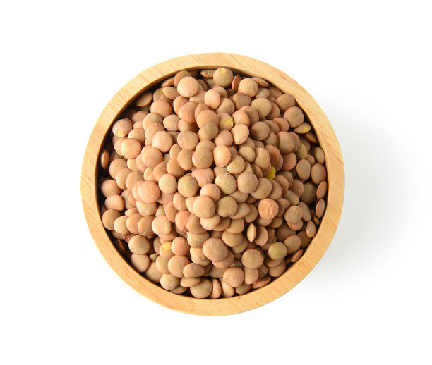 istock lentils in wood bowl on white background. with clipping path 983109504