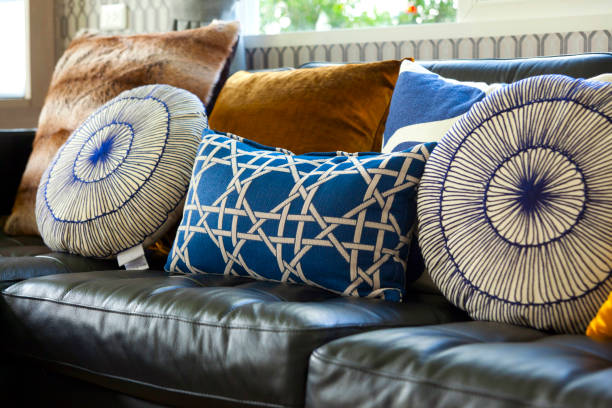 istock stylish patterned and colorful cushions on leather sofa 983124176