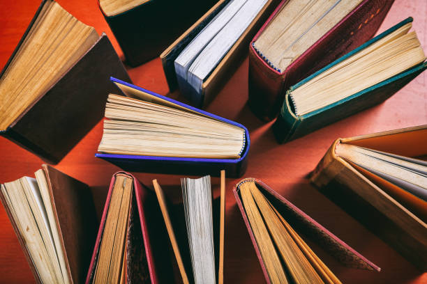 istock Old books on wooden background 983127212