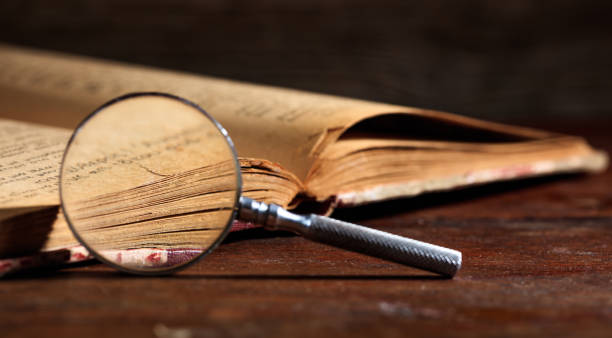 istock Vintage book and magnifying glass 983131548