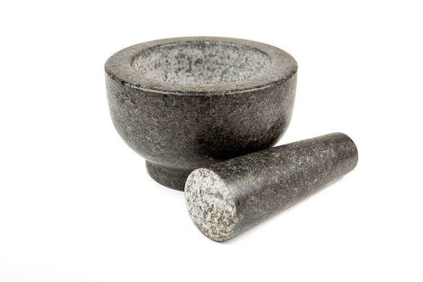 istock Heavy black stone mortar and pestle isolated on a white background 983138222