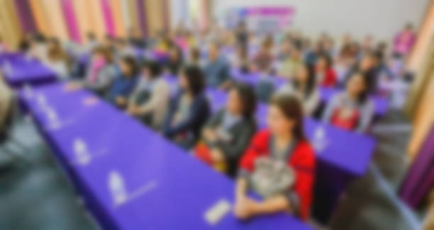 istock blurred of conference hall or seminar room with attendee background. 983138480
