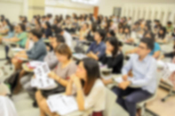 istock blurred of conference hall or seminar room with attendee background. 983138494