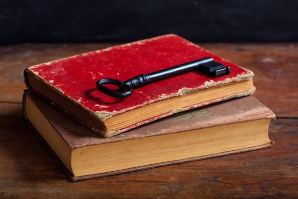 Old books and a key Old books and a key on a wooden table diary lock book cover book stock pictures, royalty-free photos & images