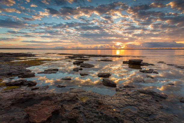 Pretty sunrise and reflections in the water with foreground rocks Beautiful sunrise reflecting across the bay at low tide.  Location  Callala Bay, part of Jervis Bay, Australia shoalhaven photos stock pictures, royalty-free photos & images