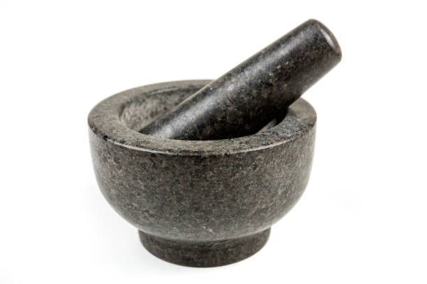 istock Heavy black stone mortar and pestle isolated on a white background 983139466