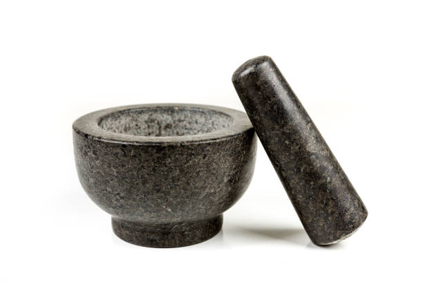 istock Heavy black stone mortar and pestle isolated on a white background 983139536
