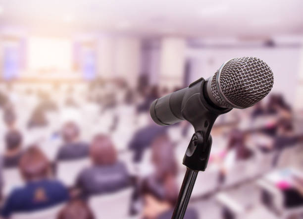 istock Microphone over the blurred business people forum Meeting Conference Training Learning Coaching Concept, Blurred background 983146772