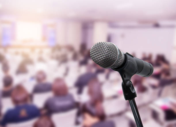 istock Microphone over the blurred business people forum Meeting Conference Training Learning Coaching Concept, Blurred background 983146776