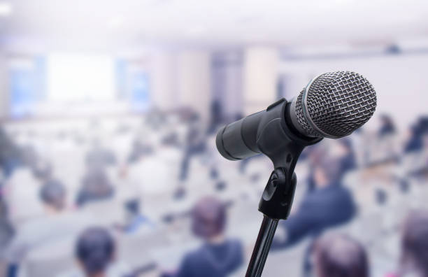 istock Microphone over the blurred business people forum Meeting Conference Training Learning Coaching Concept, Blurred background 983146778