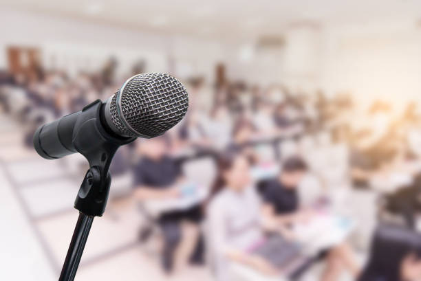 istock Microphone over the blurred business people forum Meeting Conference Training Learning Coaching Concept, Blurred background 983146792