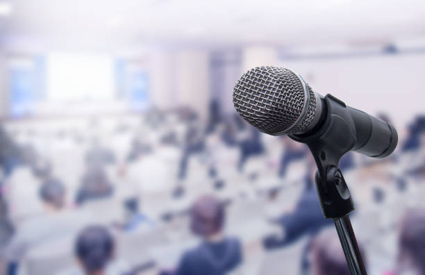 istock Microphone over the blurred business people forum Meeting Conference Training Learning Coaching Concept, Blurred background 983146794