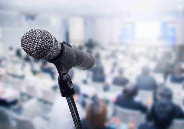 istock Microphone over the blurred business people forum Meeting Conference Training Learning Coaching Concept, Blurred background 983146796