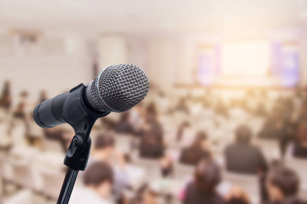 istock Microphone over the blurred business people forum Meeting Conference Training Learning Coaching Concept, Blurred background 983146800