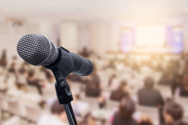 istock Microphone over the blurred business people forum Meeting Conference Training Learning Coaching Concept, Blurred background 983146810