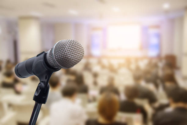 istock Microphone over the blurred business people forum Meeting Conference Training Learning Coaching Concept, Blurred background 983146820