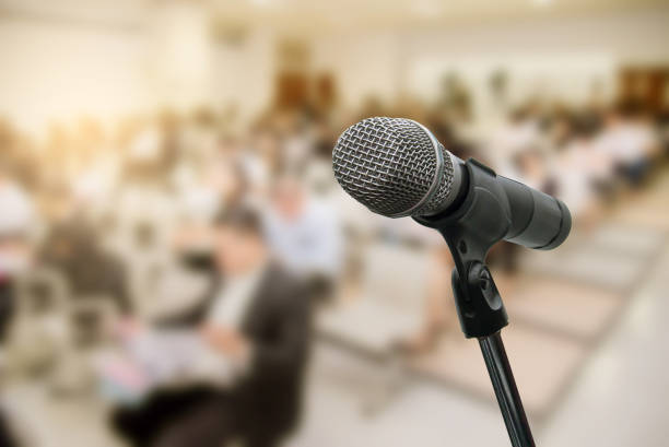 istock Microphone over the blurred business people forum Meeting Conference Training Learning Coaching Concept, Blurred background 983146826