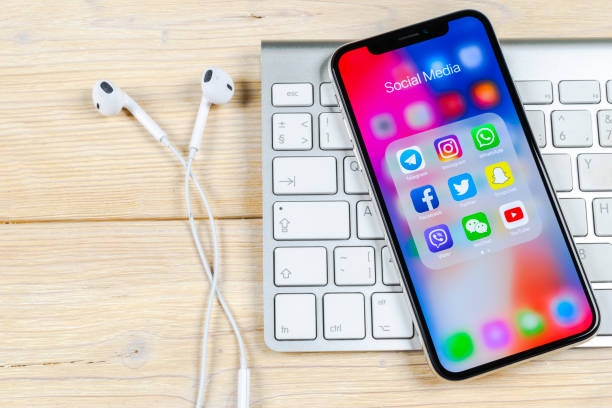 Apple iPhone X on office desk with icons of social media facebook, instagram, twitter, snapchat application on screen. Social network. Starting social media app. stock photo