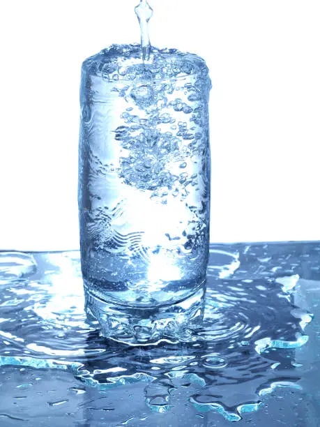 pouring water to glass with overflow