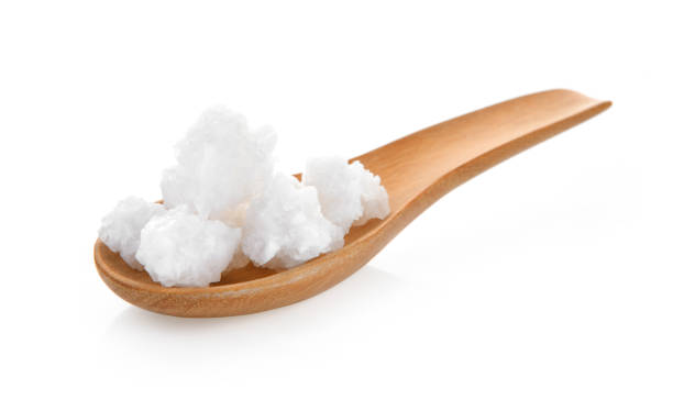 istock salt in wood spoon on white background 983188996