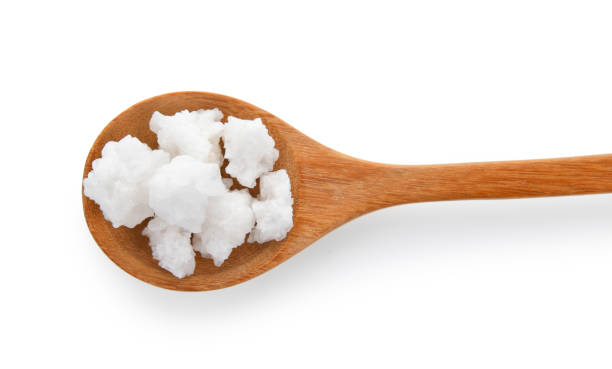 istock salt in wood spoon on white background 983196114
