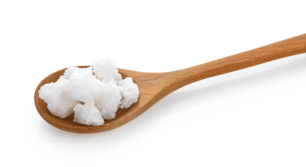istock salt in wood spoon on white background 983196188