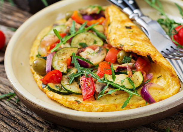 Omelet with tomatoes, zucchini and mushrooms. Omelette breakfast. Healthy food. stock photo